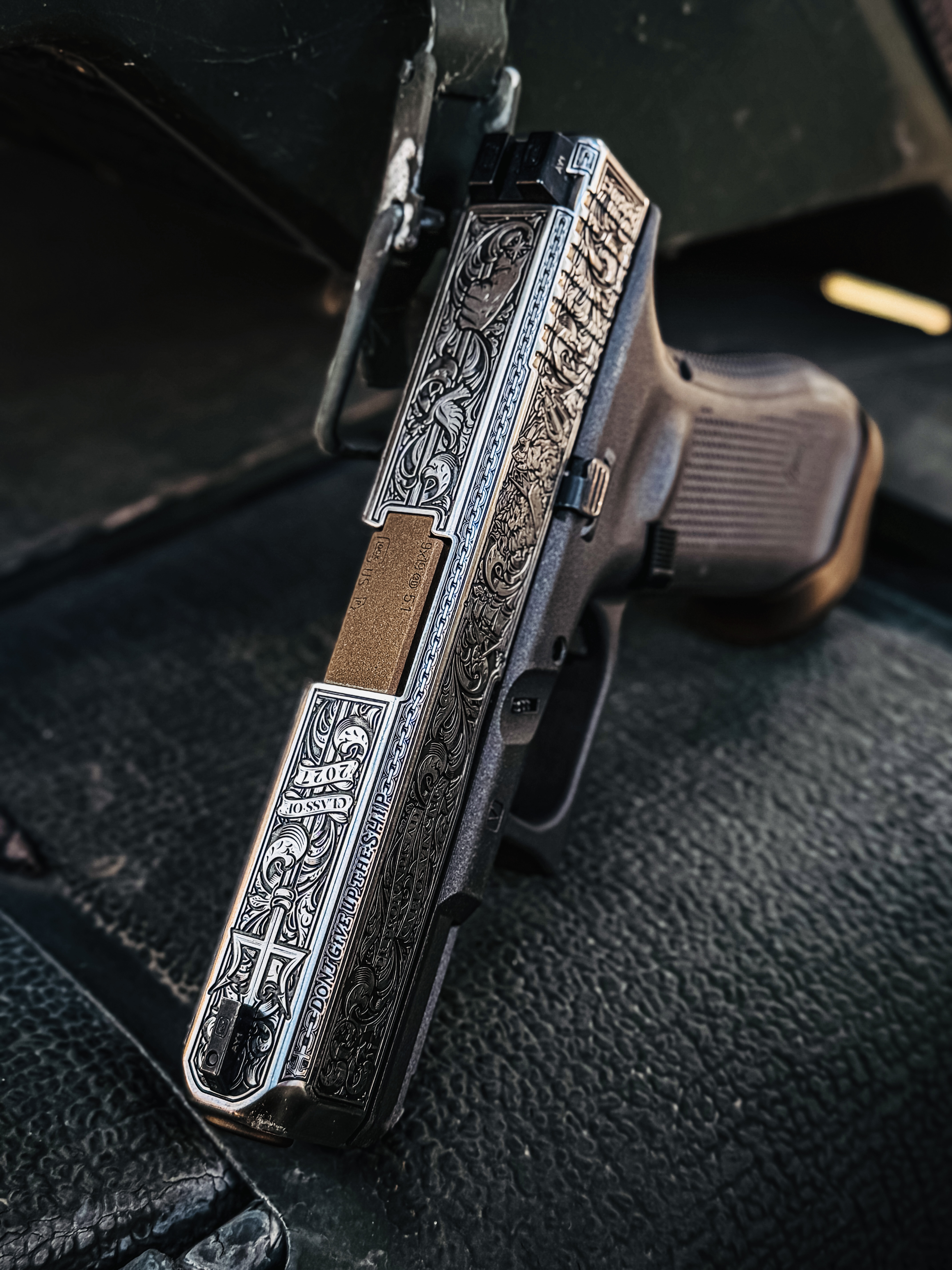 USNA Class of 2027 GLOCK 19X V — resting against vehicle door, “Don't Give Up the Ship” engraving
